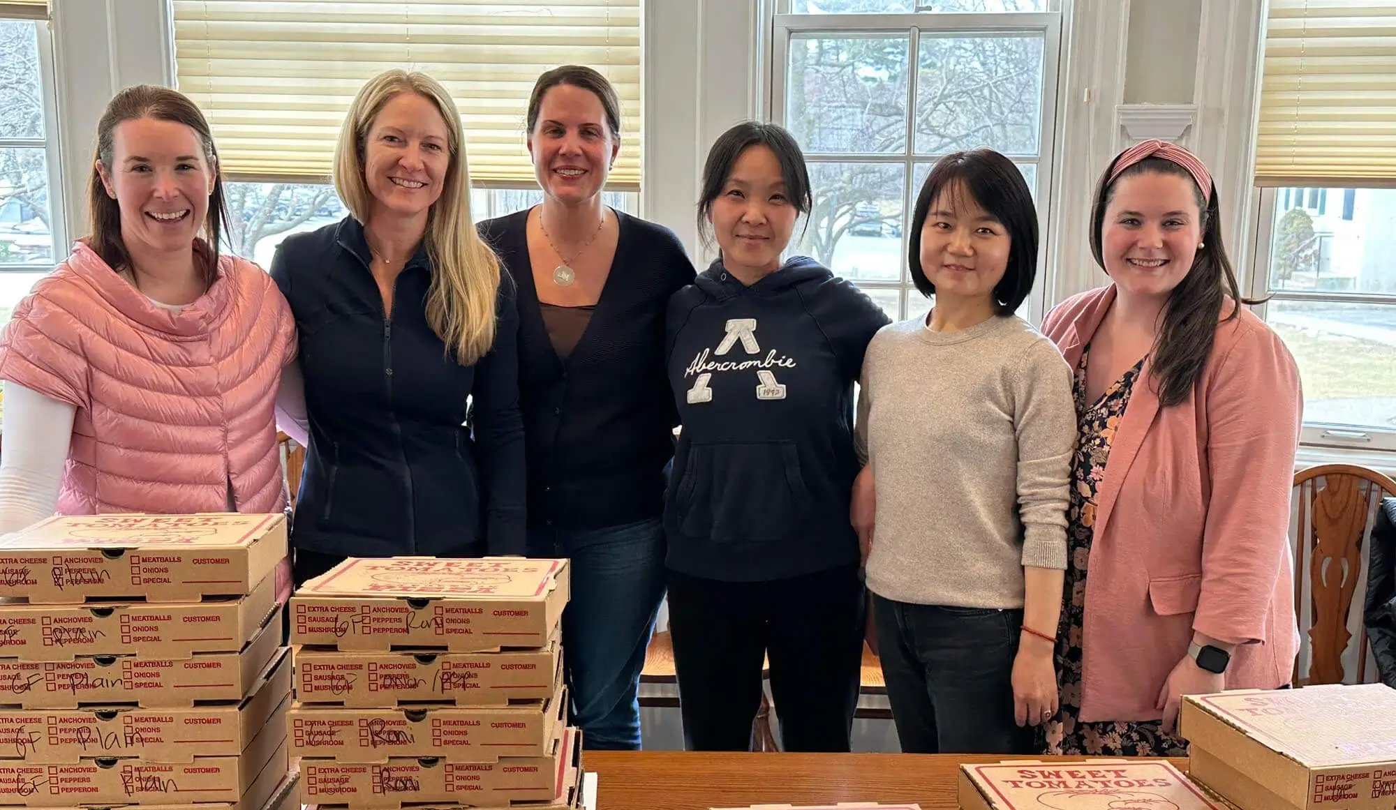 教職員への感謝 - ピザの箱の後ろに立つ女性たち